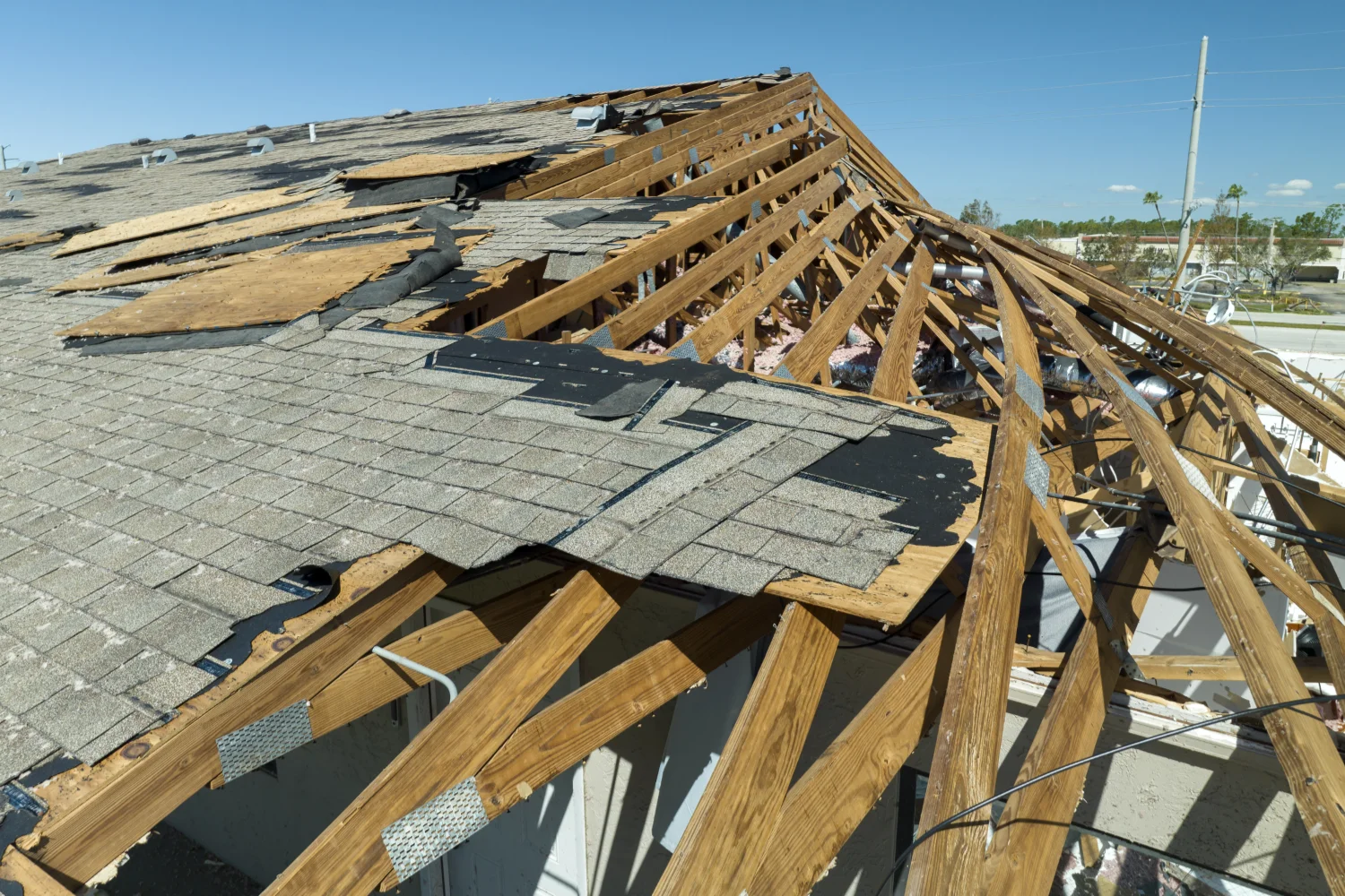 Storm-damaged roof featuring scattered shingles and structural exposure. Storm Damage Repair. What Homeowners should know.